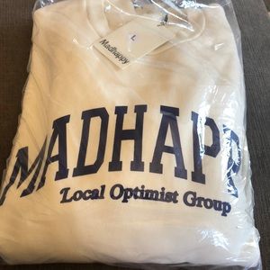 Blue letters. Off white sweater.